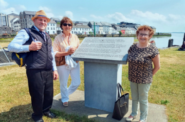 tour guide with clients stand at poetry plaque